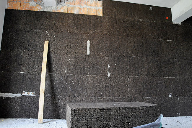 Cork boards behing installed on a brick wall seprating 2 apartments in Amadeo 2