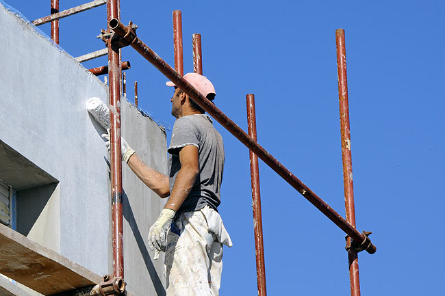 Applying white Ceresit primer CT 16 on Amadeo II facade